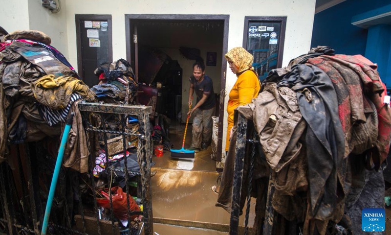 A man cleans mud from his house after flood in Garut, West Java, Indonesia, July 16, 2022.Photo:Xinhua