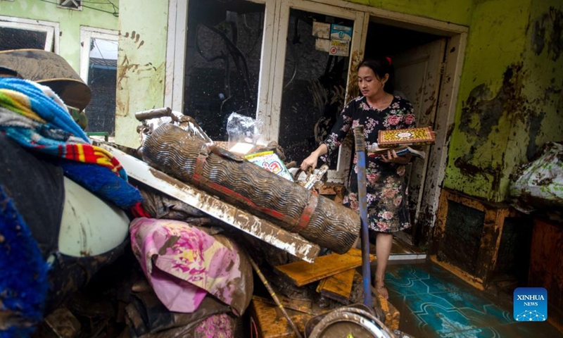 A woman cleans mud from his house after flood in Garut, West Java, Indonesia, July 16, 2022.Photo:Xinhua