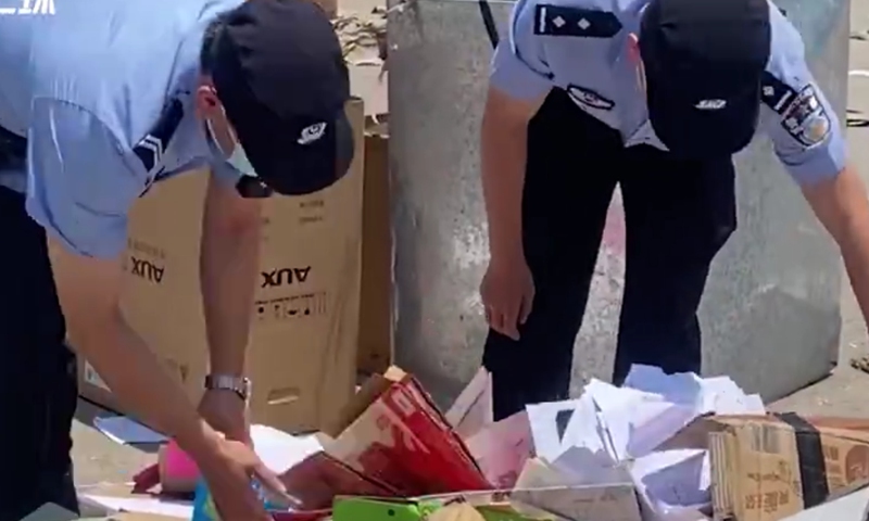 Officers help retrieve 10,000 yuan from a recycling station. Screenshot of The Paper