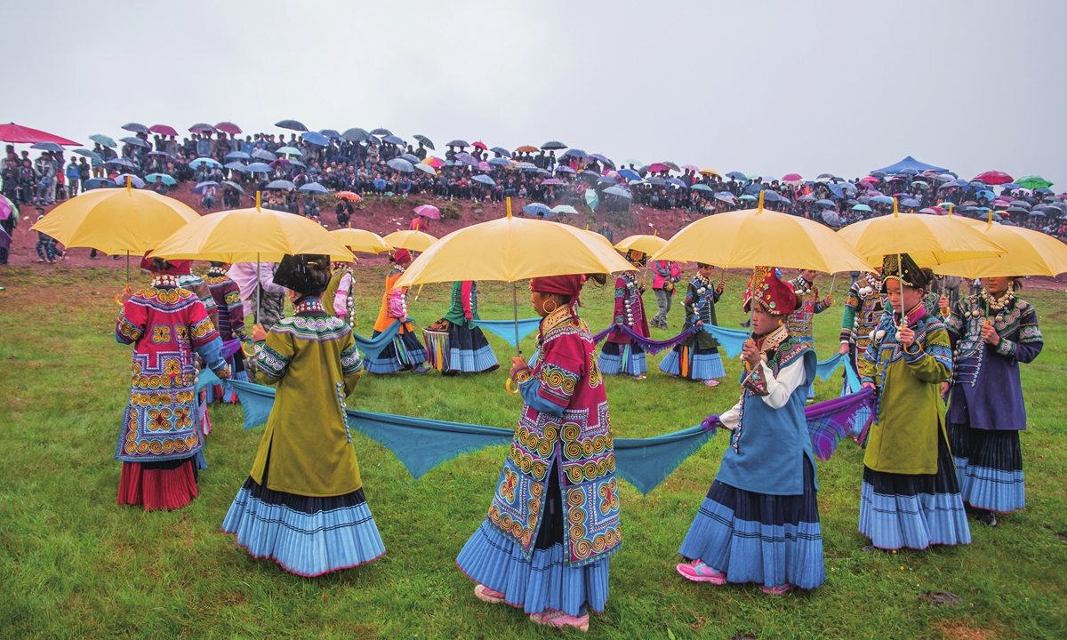 Women from China's Yi ethnic group hold umbrellas for a beauty contest during the local Torch Festival. Photo: IC