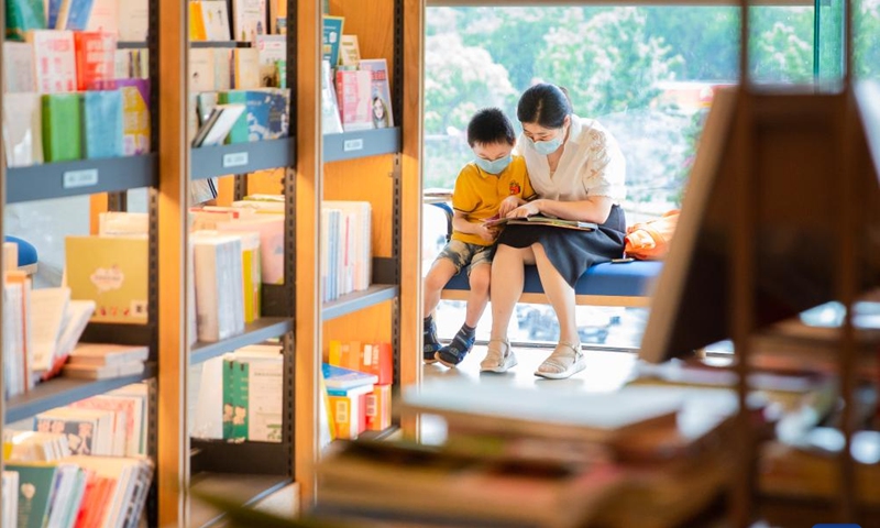 A child and his parent read a book together at a bookstore in Nanjing, east China's Jiangsu Province, July 17, 2022.Photo:Xinhua