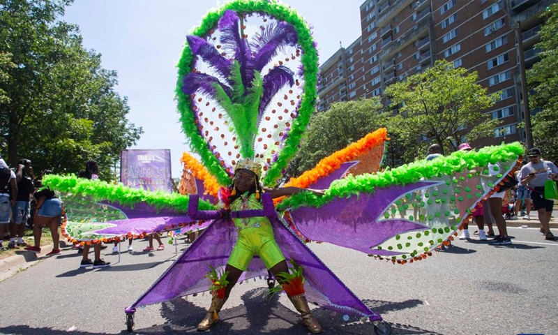 A dressed-up girl poses for photos with her float during the junior parade of the 2022 Toronto Caribbean Carnival in Toronto, Canada, on July 16, 2022.Photo:Xinhua