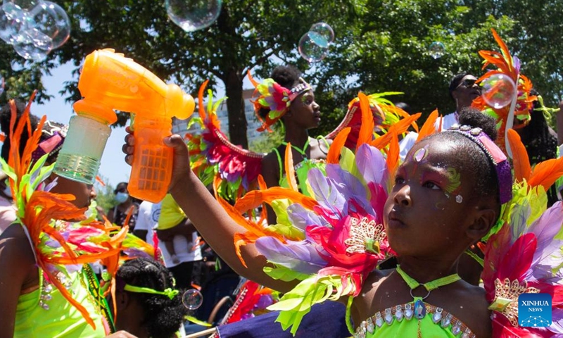 A dressed-up girl makes bubbles with a bubble gun toy during the junior parade of the 2022 Toronto Caribbean Carnival in Toronto, Canada, on July 16, 2022.Photo:Xinhua