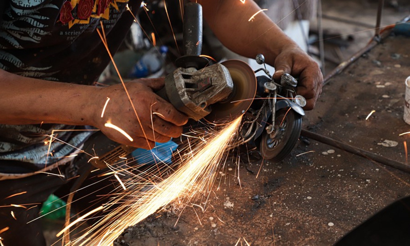 Fakher Hamad, a hearing impaired Palestinian, works on making art from iron at his workshop in Beit Hanoun town in the northern Gaza Strip, on July 18, 2022.(Photo: Xinhua)