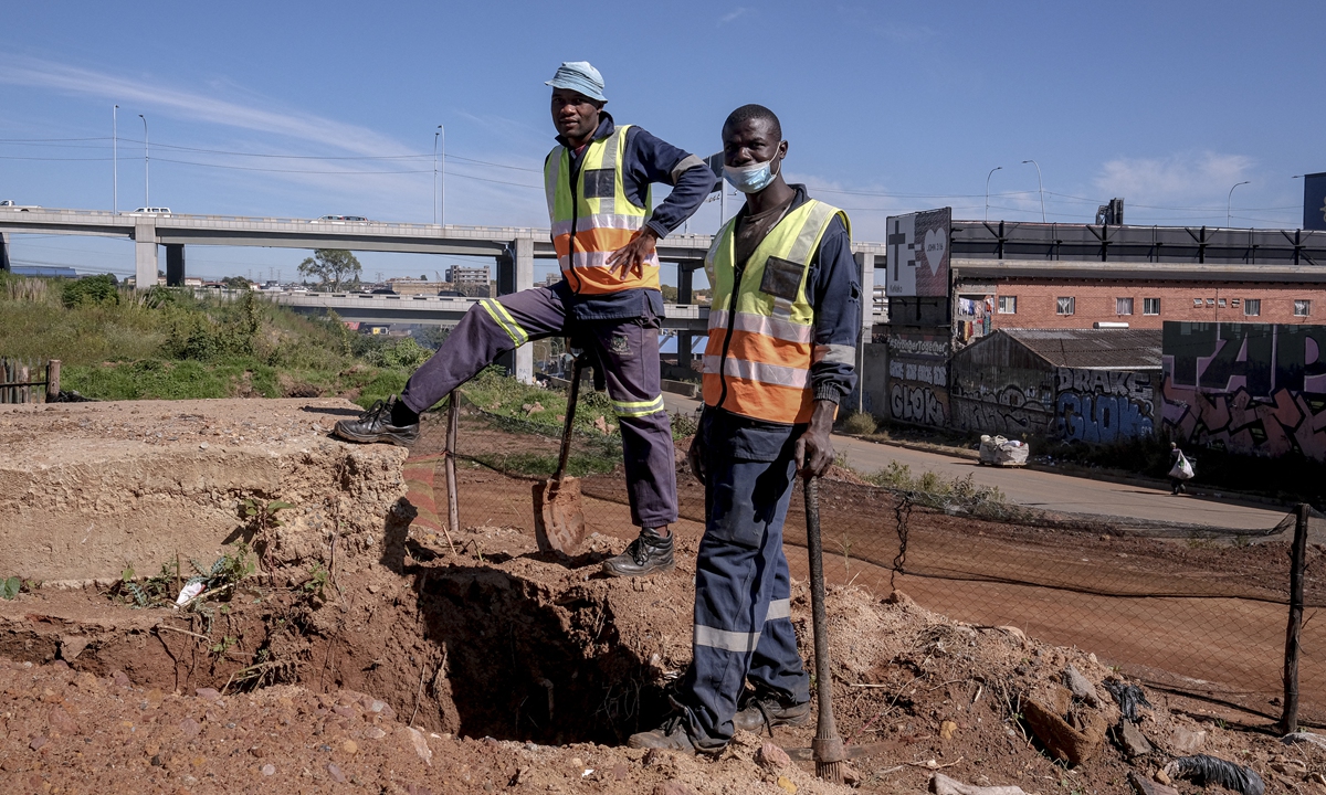 Mine workers look on at a previously operational gold mine being rehabilitated in Johannesburg's CBD, South Africa on April 14, 2022. Photo: AFP
