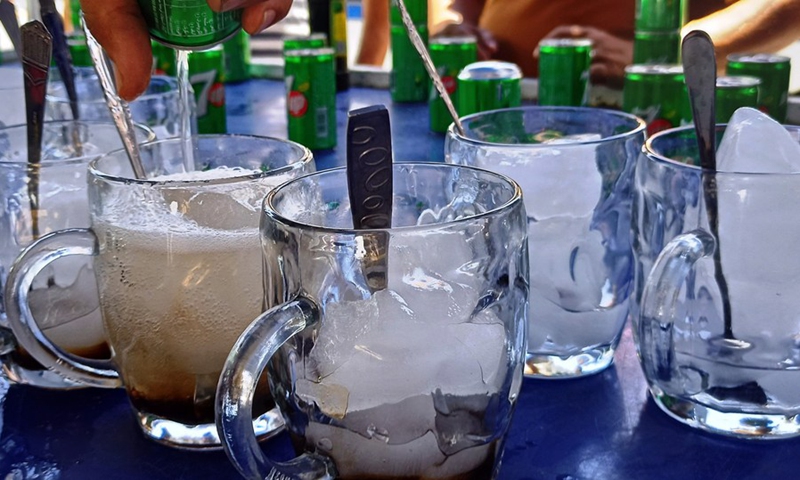 Iraqis have soft drinks to cool off amid a heatwave at a local market in Baghdad, Iraq on July 20, 2022.(Photo: Xinhua)