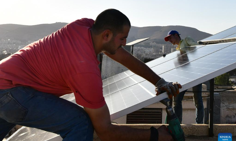 Workers install solar panels atop a building in the Damascus, Syria, July 23, 2022. Solar power systems are becoming more popular in Damascus as a result of the long power cuts. Photo: Xinhua