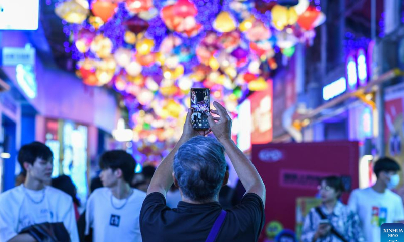 A visitor takes photos of a local market at the Qingyun Road in Nanming District of Guiyang, capital city of southwest China's Guizhou Province, July 21, 2022. Photo: Xinhua