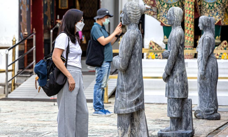 Tourists view stone statues at Wat Phra Kaew temple of the Grand Palace in Bangkok, Thailand, July 20, 2022. (Xinhua/Wang Teng)