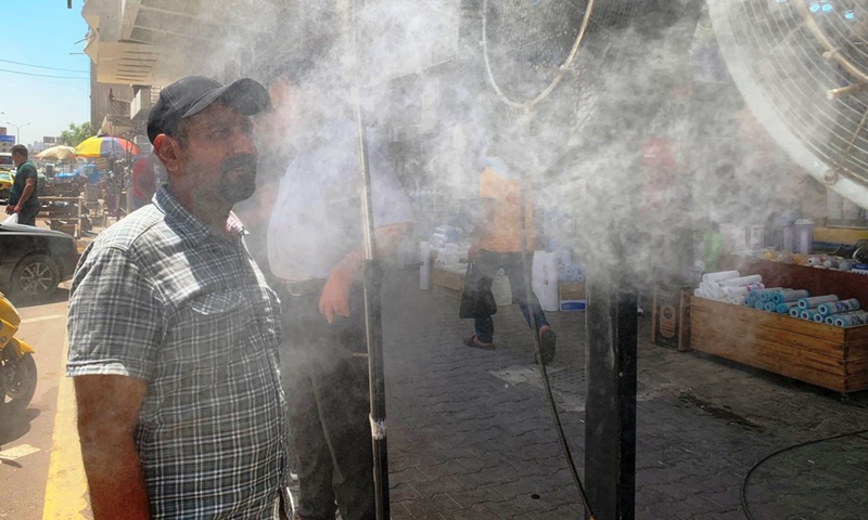 An Iraqi man cools off in front of a fan amid a heatwave in Baghdad, Iraq on July 20, 2022.(Photo: Xinhua)