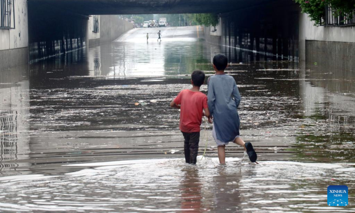 Children wade through flood water after heavy monsoon rains in Lahore, Pakistan, July 21, 2022. Photo:Xinhua