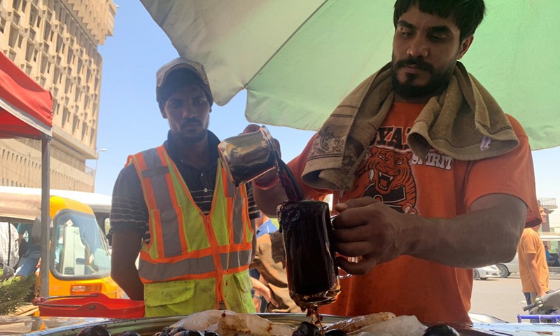 Iraqis have soft drinks to cool off amid a heatwave at a local market in Baghdad, Iraq on July 20, 2022.(Photo: Xinhua)