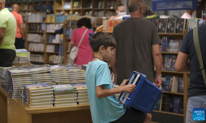 People select books on board Logos Hope during a floating book fair in Valletta, Malta, July 14, 2022. About 300 people from 60 countries are touring the world on board the largest-ever floating book fair to spread the joy of reading and bring hope and help to the needy. Photo: Xinhua