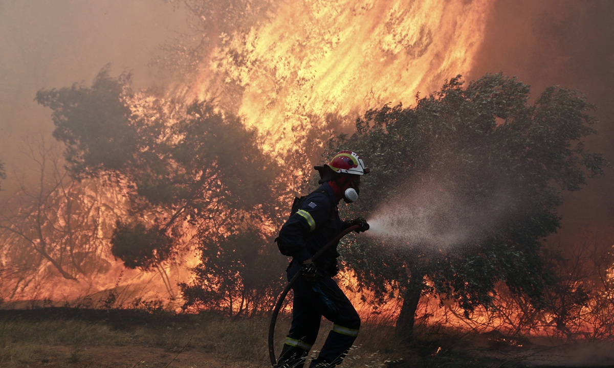Firefighters confront blazes during a forest fire that broke at the suburb of Pallini, east of Athens, Greece, on Wednesday July 20, 2022. Photo: VCG