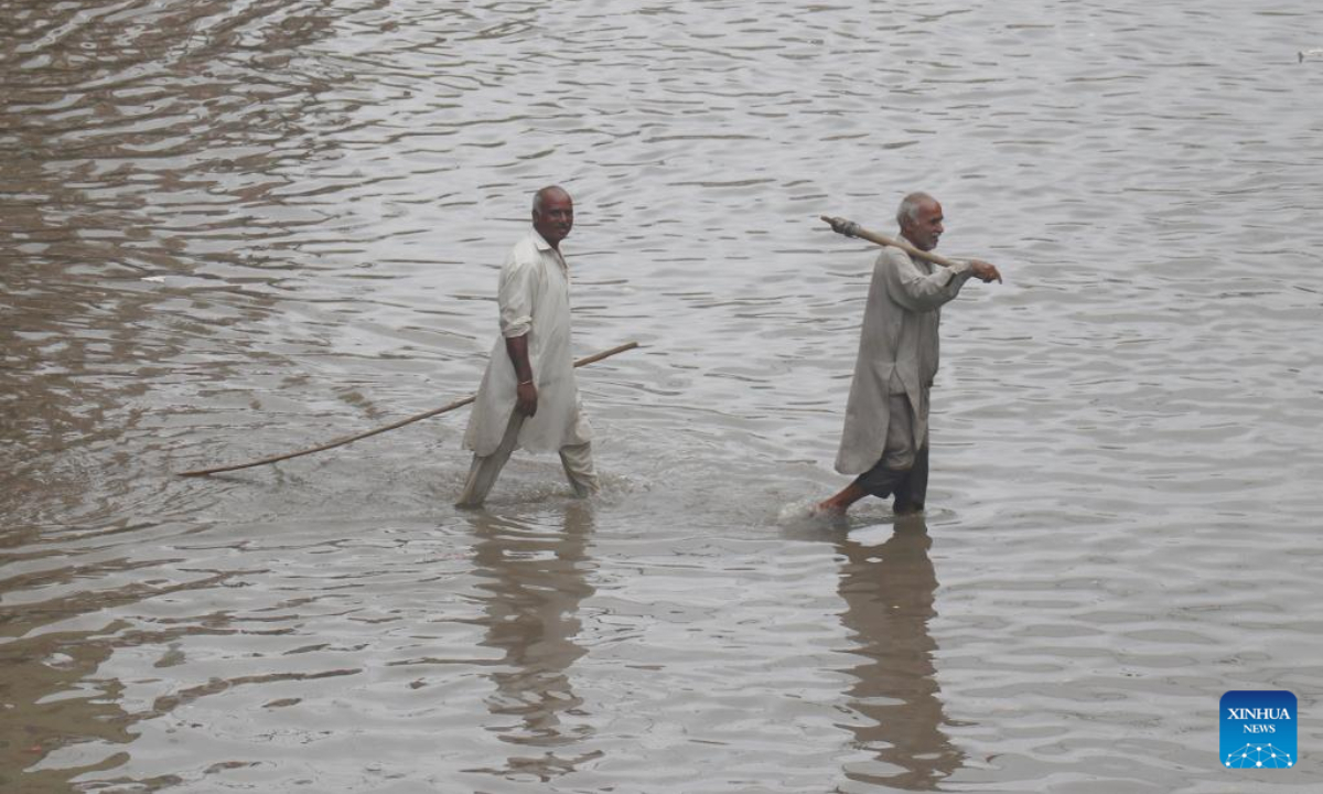 People wade through flood water after heavy monsoon rains in Lahore, Pakistan, July 21, 2022. Photo:Xinhua