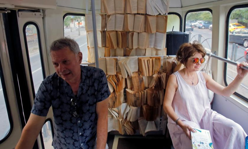People attend a cultural event called Tramvaiul Bookuresti (Bookarest Tramway) in a vintage tram in Bucharest, capital of Romania, July 23, 2022. Organized by the Cultural Centre of the Townhall, the cultural event is hosted in a vintage tramway where people could listen to poetry, music and historic stories about the town during a two-hour trip.  Photo: Xinhua