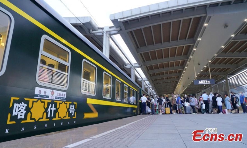 2022年7月25日，乘客在中国西北部新疆维吾尔自治区乌鲁木齐登上火车。（照片：中新社/张山）