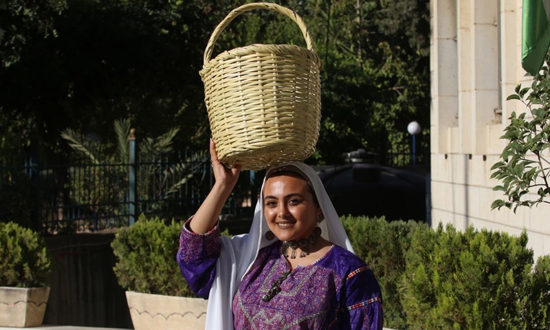 A Palestinian model displays a traditional Palestinian dress during a fashion show celebrating Palestinian Traditional Dress and Heritage Day in the West Bank city of Al-Bireh, on July 25, 2022.(Photo: Xinhua)