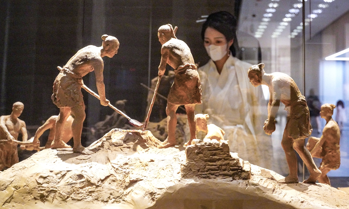 A woman in <em>Hanfu</em> (a traditional Chinese costume), learns about a site dating from the Shang Dynasty (1600-1046 BC) at the Museum of Ruins of a City During the Shang Dynasty in Zhengzhou, Central China's Henan Province on July 26, 2022. The museum opened on the same day after nearly half a year of renovation. Photo: VCG