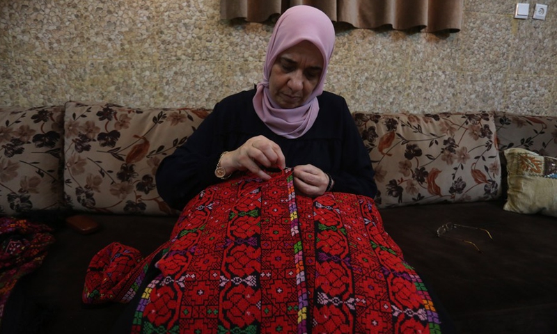 Ebtisam Abu Jaber, a Palestinian designer from the West Bank, works at her home in Balata refugee camp in the city of Nablus, on July 22, 2022.(Photo: Xinhua)