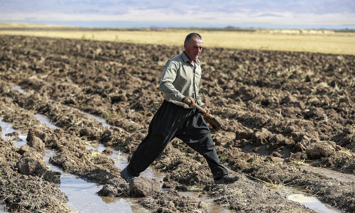 A Kurdish farmer digs irrigation ditches for water supplied from a well, at a farm in the Rania district near the Dukan dam northwest of Iraq's northeastern city of Sulaimaniyah on July 2, 2022. Photo: AFP