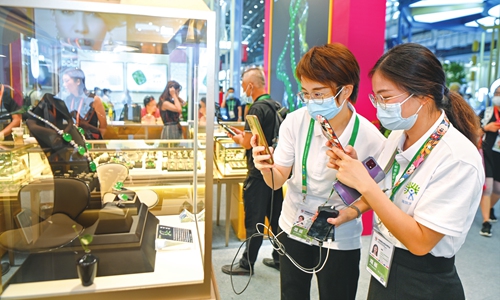 People take photo of jewelry at the second China International Consumer Products Expo. Photo: VCG