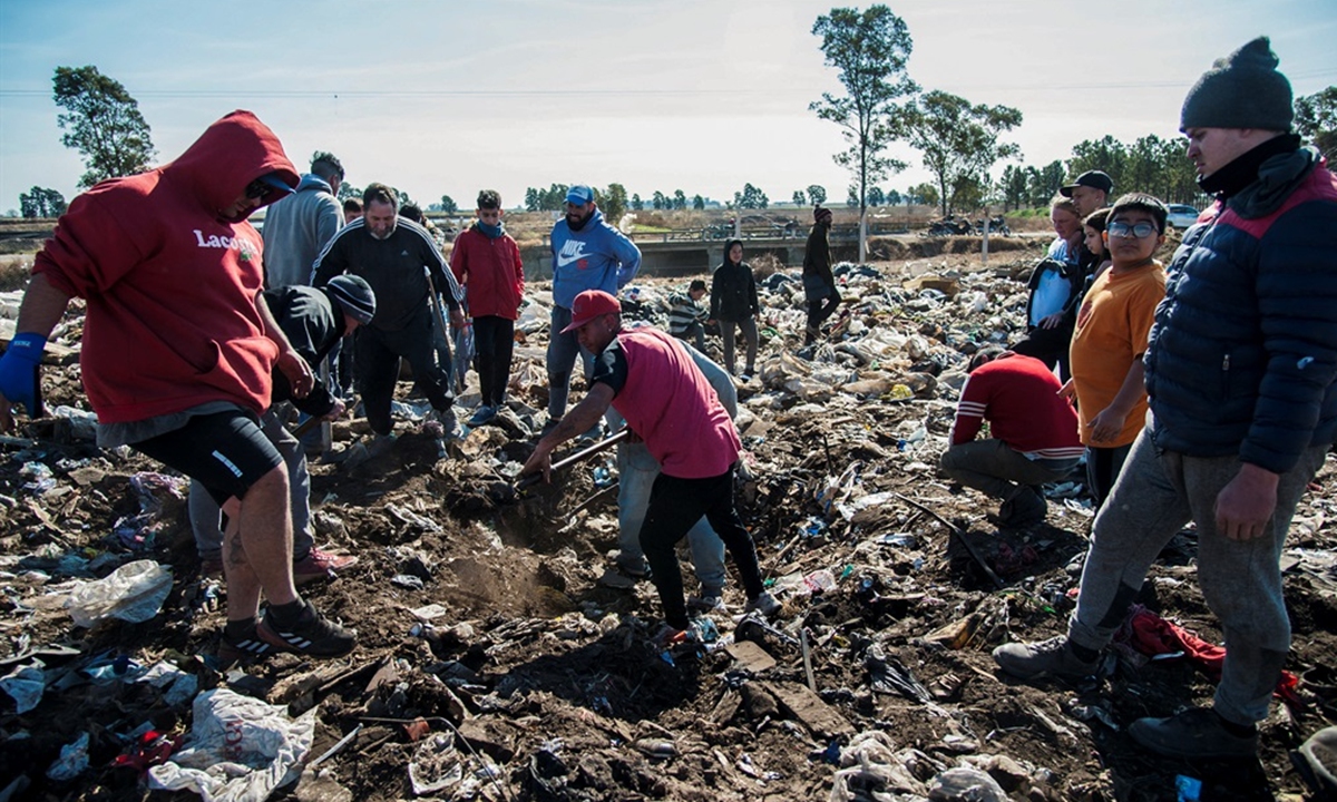 People look for dollar notes among the garbage, in the dump of Las Parejas, Santa Fe province, Argentina. Photo: AFP