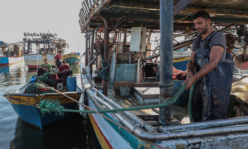 Palestinian fishermen work on a fishing boat ahead of going to fish in the Gaza sea on July 26, 2022. 
(Photo: Xinhua)