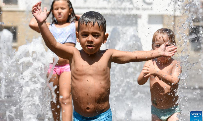 Children play at a fountain to cool off in Coria, Spain on July 30, 2022. Photo: Xinhua