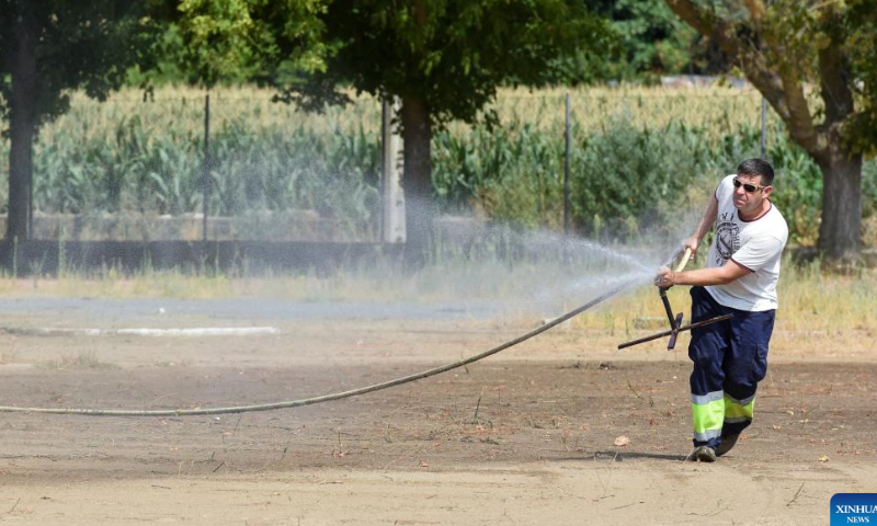 A worker works with a sprinkler at a park in Coria, Spain on July 30, 2022. Photo: Xinhua