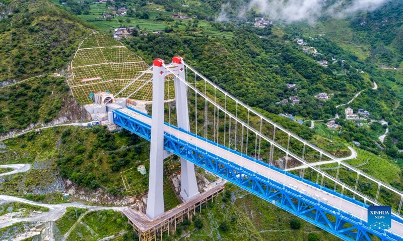 Aerial photo taken on July 27, 2022 shows the Jinsha River grand bridge linked with the entrance of the Haba Snow Mountain tunnel along the Lijiang-Shangri-La railway in southwest China's Yunnan Province. With a designed speed of 120 kilometers per hour, the 140-kilometer Lijiang-Shangri-La railway is expected to shorten the travel time between Lijiang and Shangri-La after its operation.(Photo: Xinhua)