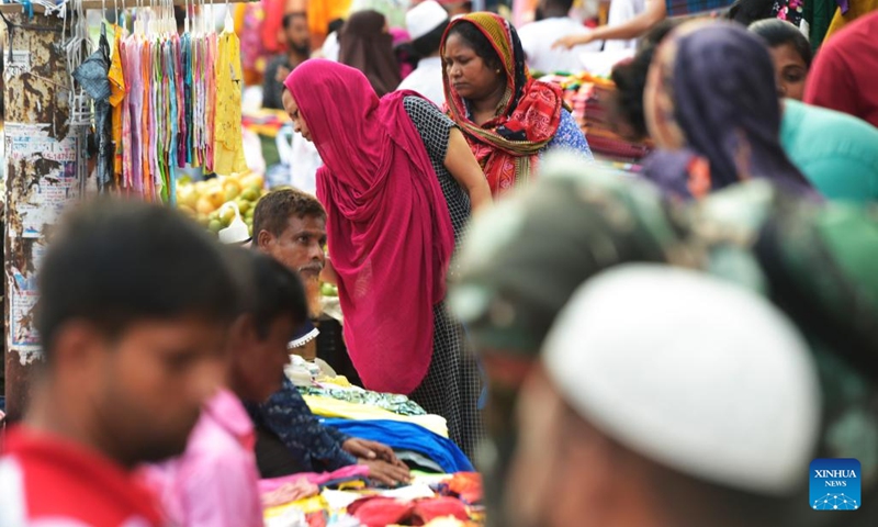 Female customers buy garment items at a roadside stall in Dhaka, Bangladesh, on July 27, 2022.(Photo: Xinhua)