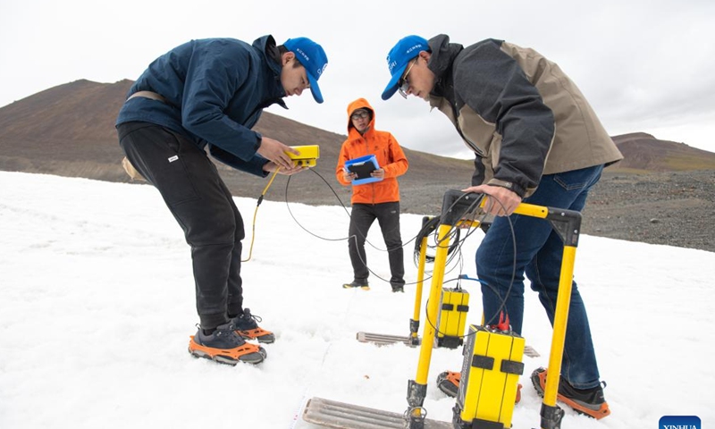 Dong Shiqi (L), Ding Peizhong (C) and Fan Yue, members of a scientific expedition team of the Changjiang River Scientific Research Institute (CRSRI) conduct investigation with ground-penetrating radar at Mount Geladandong in northwest China's Qinghai Province, July 28, 2022. Chinese scientists launched an expedition on July 24 in the headwater regions of the Yangtze and Lancang rivers in northwest China's Qinghai Province, to investigate the regions' water resources and ecological environment. Photo: Xinhua 