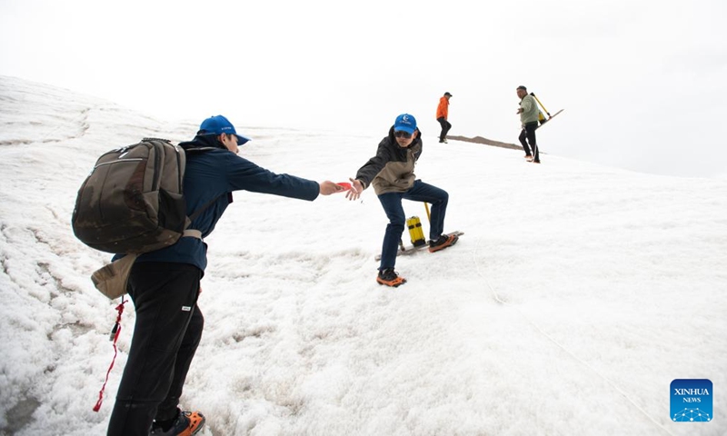 Members of a scientific expedition team of the Changjiang River Scientific Research Institute (CRSRI) transport investigation gears at Mount Geladandong in northwest China's Qinghai Province, July 28, 2022. Photo: Xinhua 