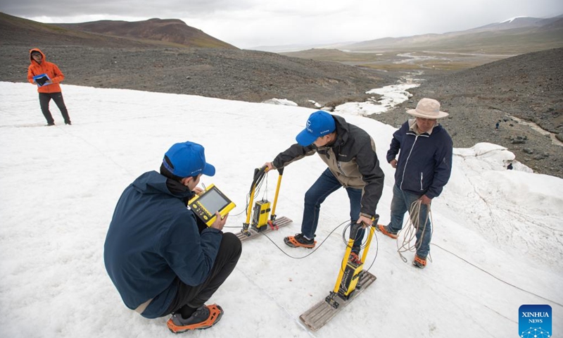Ding Peizhong (1st L), Dong Shiqi (2nd L), and Fan Yue (3rd L), members of a scientific expedition team of the Changjiang River Scientific Research Institute (CRSRI) conduct investigation with ground-penetrating radar at Mount Geladandong in northwest China's Qinghai Province, July 28, 2022. Photo: Xinhua 