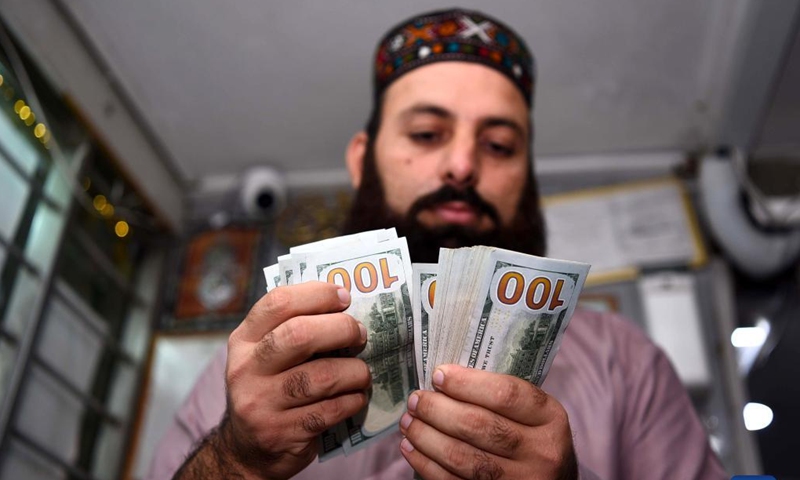 A currency changer counts U.S. dollar notes in Rawalpindi, Pakistan, on July 29, 2022. Pakistani rupee rebounded in the last trading session of the week on Friday, recording minor gains against the U.S. dollar after extending losses for 10 consecutive sessions in the interbank market, according to the State Bank of Pakistan (SBP).(Photo: Xinhua)