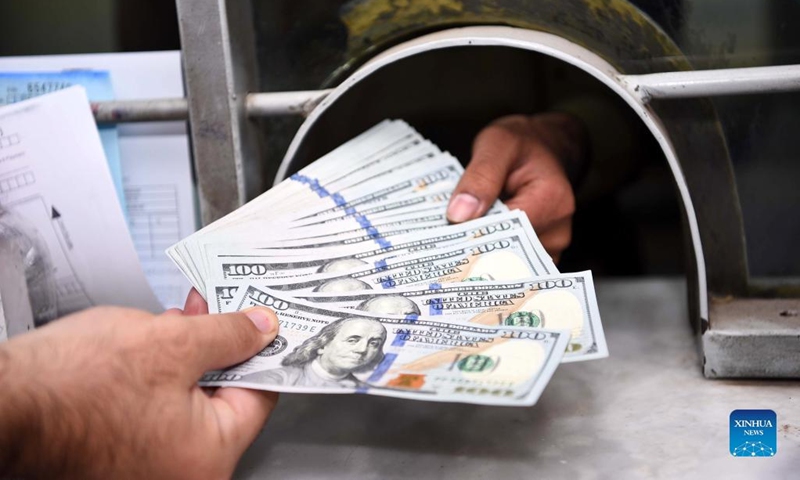 A currency changer gives U.S. dollar notes to a customer in Rawalpindi, Pakistan, on July 29, 2022. Pakistani rupee rebounded in the last trading session of the week on Friday, recording minor gains against the U.S. dollar after extending losses for 10 consecutive sessions in the interbank market, according to the State Bank of Pakistan (SBP).(Photo: Xinhua)