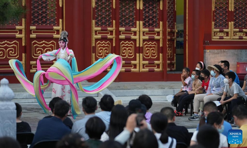 People watch a Peking opera performance at Miaoying Temple, also called Baita Temple, in Beijing, capital of China, July 30, 2022. A series of cultural activities will be held at night at Miaoying Temple recently. (Xinhua/Ju Huanzong)