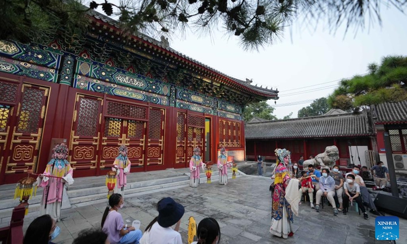 People watch a Peking Opera performance at Miaoying Temple, also called Baita Temple, in Beijing, capital of China, July 30, 2022. A series of cultural activities will be held at Miaoying Temple recently.  (Xinhua/Ju Huanzong)