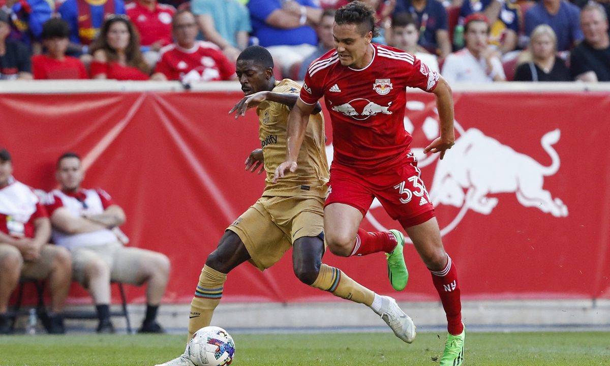 Barcelona's Ousmane Dembele (left) vies for the ball with NY Red Bulls defender Aaron Long during the international friendly soccer match at Red Bull Arena in Harrison, New Jersey, the US on July 30, 2022. Photo: AFP