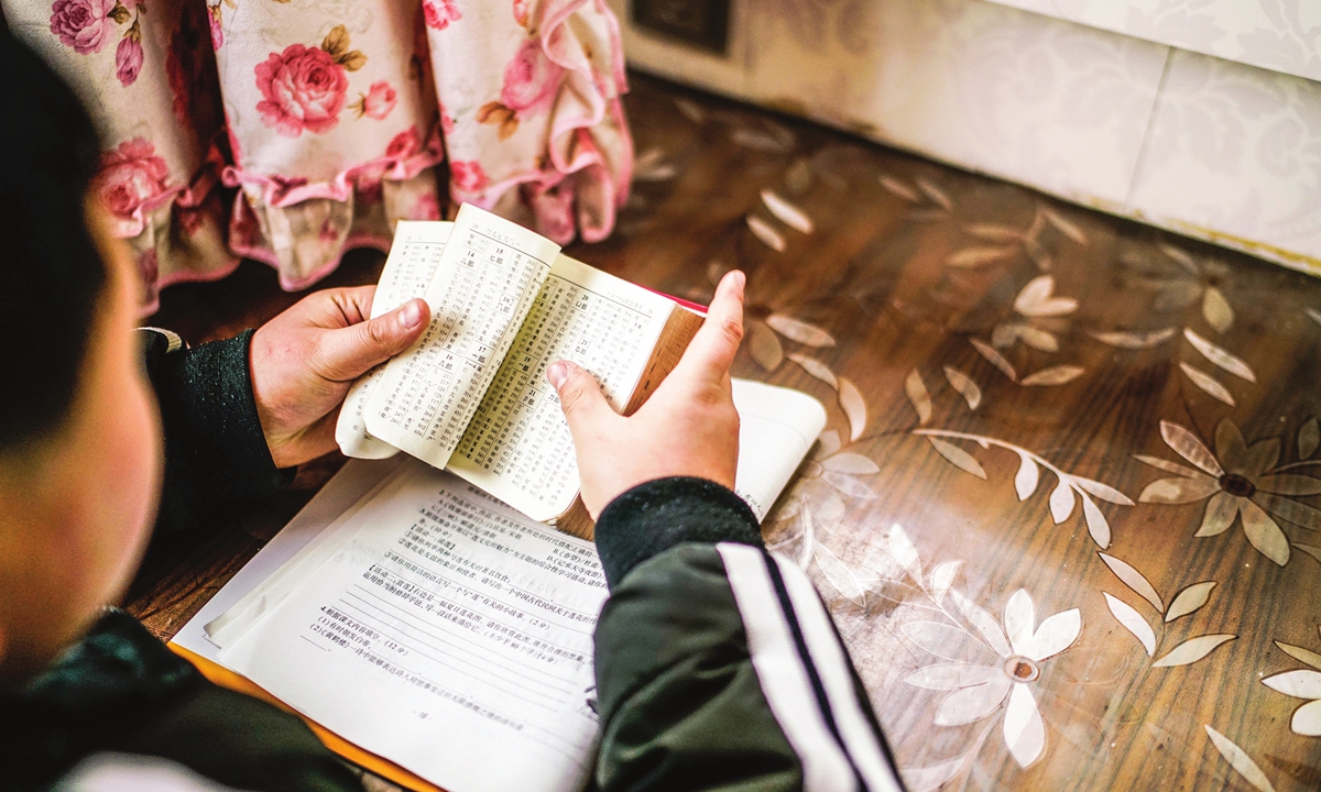 An elementary school student checks a dictionary. Photo: VCG