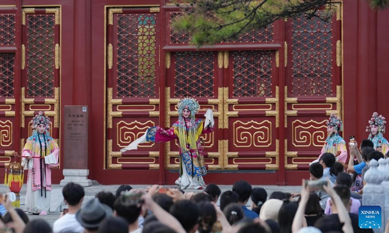 People watch a Peking opera performance at Miaoying Temple, also called Baita Temple, in Beijing, capital of China, July 30, 2022. A series of cultural activities will be held at night at Miaoying Temple recently. (Xinhua/Ju Huanzong)