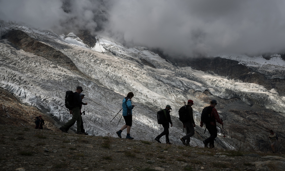 Hikers walk next to the Fee Glacier above the Swiss Alpine resort of Saas-Fee on July 30, 2022. Photo: AFP