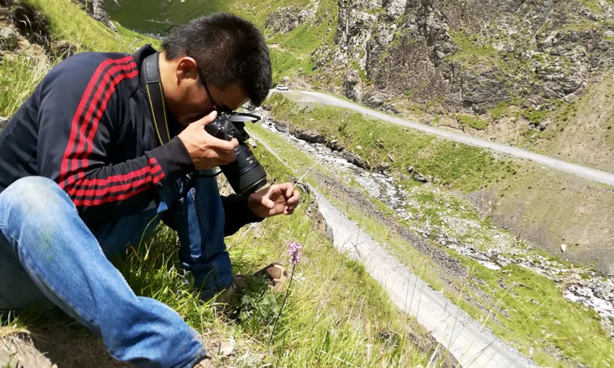 Yang Zongzong takes photos of a flower. Photo: Courtesy of Yang Zongzong