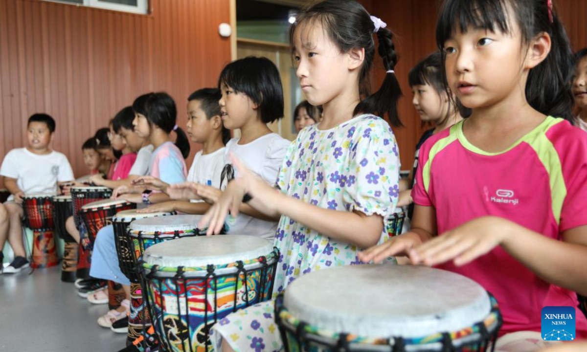 Children learn to play African drums as part of a summer caring program at a primary school in Shenyang, northeast China's Liaoning Province, Aug 4, 2022. Photo:Xinhua