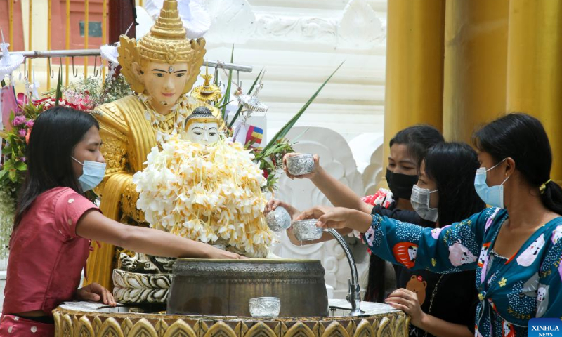 People wearing face masks pour water onto a statue of Buddha at Shwedagon Pagoda in Yangon, Myanmar, on Aug. 6, 2022. Myanmar has recorded no new COVID-19 deaths over the past 122 days, the longest stretch without any fatalities from the virus since the start of the pandemic in the country, the Ministry of Health said on Saturday. Photo: Xinhua