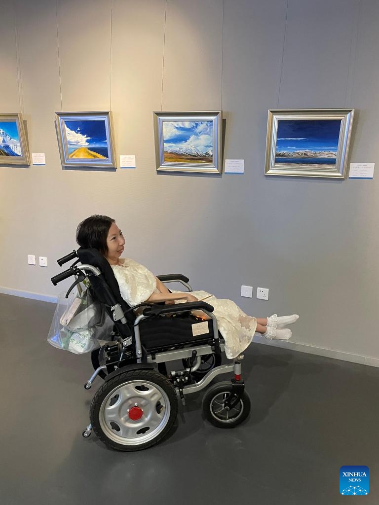 Zhang Junli views paintings during the exhibition of her works in Taiyuan, capital of north China's Shanxi Province, July 26, 2022. Photo:Xinhua
