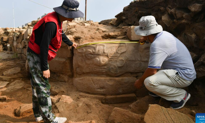 Archeologists measure a recently-excavated stone carvings at the Shimao ruins, an important prehistoric site in Shenmu City, northwest China's Shaanxi Province, Aug. 6, 2022. Photo: Xinhua