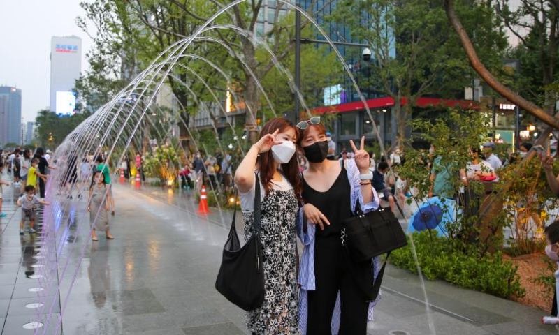 Visitors pose for photos at a fountain corridor of the Gwanghwamun Square in Seoul, South Korea, Aug. 6, 2022. Gwanghwamun Square, a major landmark in Seoul, opened to the public Saturday after nearly two years of renovation. Photo: Xinhua