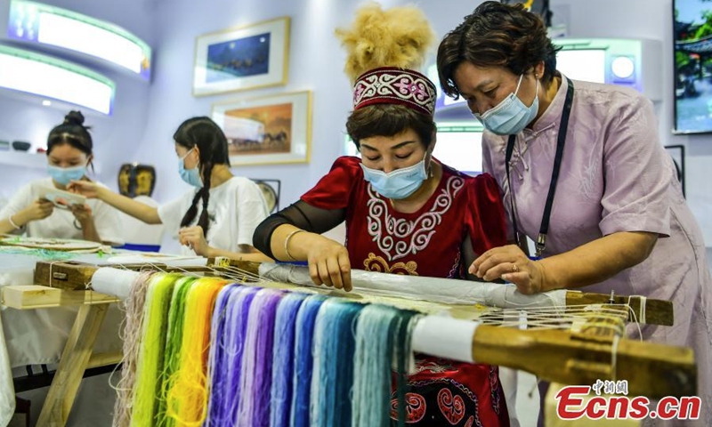 An inheritor displays Suzhou embroidery techniques during an intangible cultural heritage exhibition in Xinjiang Art Museum, Urumqi, northwest China's Xinjiang Uyghur Autonomous Region, July 31, 2022. (Photo: China News Service/Liu Xin)
